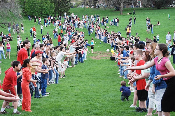 Two long lines of people participating in an egg toss.